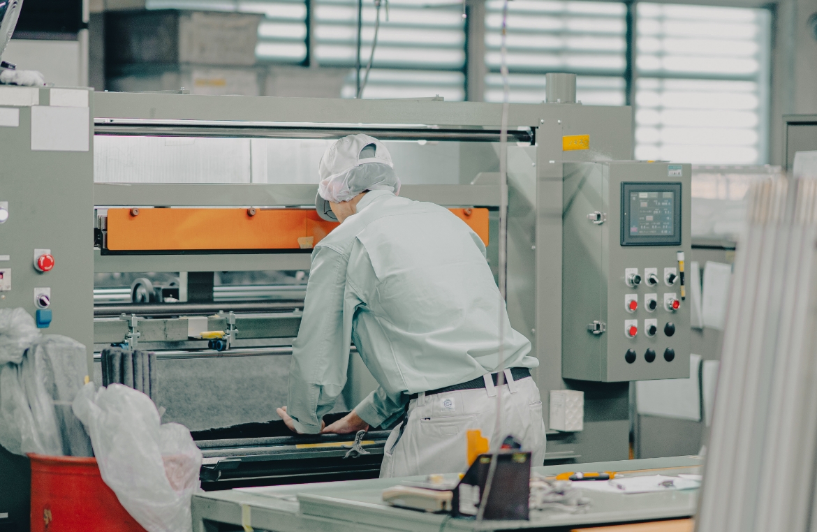 活性炭繊維シートをロール状に巻く男性